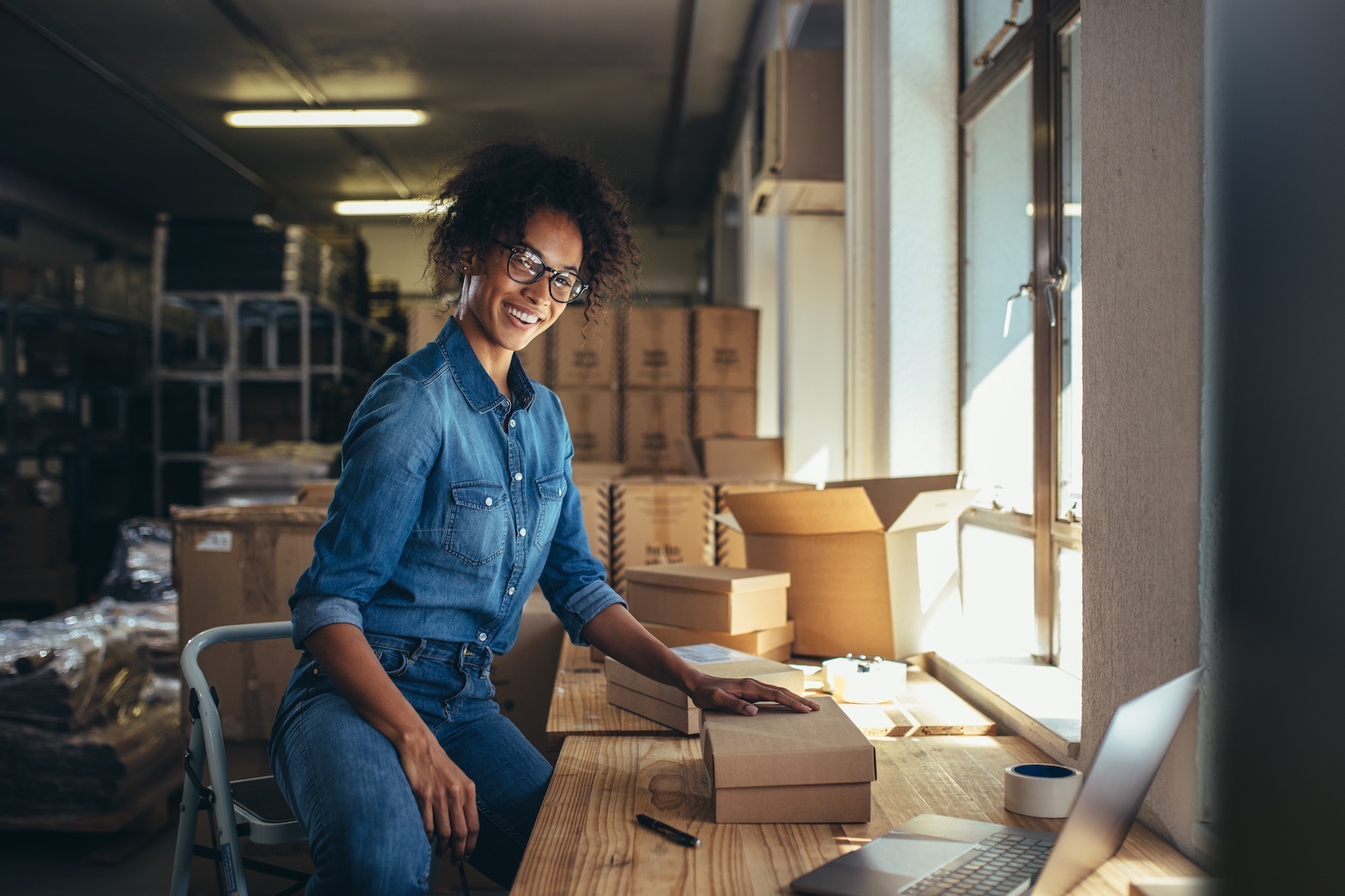 Shipping as a Revenue Stream: Factors that Affect Live Rates and How to Make them Work for You (Part 2) women packing a parcel