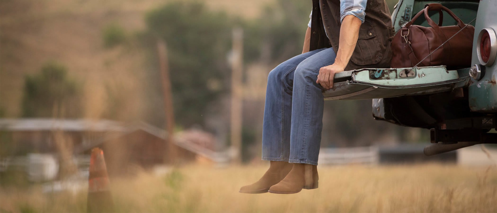 Shopify DTC Retailer, Tecovas Creates an Amazon-Like Checkout Experience Man sits on pickup tailgate wearing Tecovas' boots